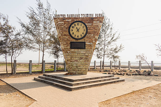 istock Elegant triangular clock structure welcoming visitors to Sabrang with blue ocean waves in distant background. 2234542277