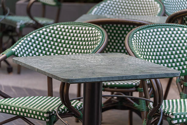 istock Empty green and white cafe chairs and a marble table await guests. 2234542703