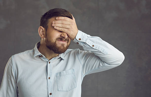 istock Man facepalming feeling awfully ashamed and embarrassed of a stupid mistake he's made 2234542950