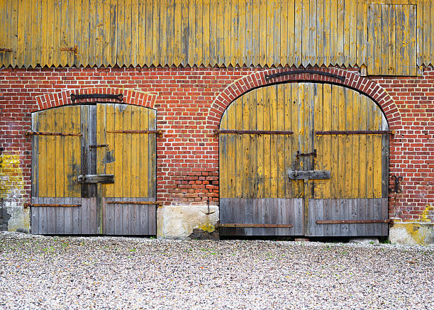 Weathered wooden shed doors with padlocks in a poor state of repair.  Grand Island, New York.  Soft focus.
