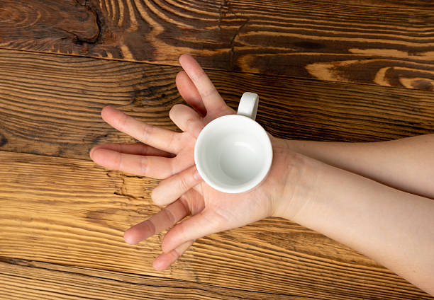 istock Hand Holds Cup, Empty White Cup in Hands, Coffee Mug, Teacup Mockup, Cup in Arms on Wooden Table 2234547614