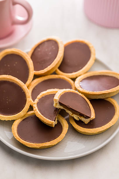 istock Sweet chocolate tartelettes on plate on white table. 2234549492
