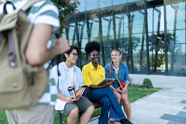 istock Diverse university or college students relaxing on bench outside modern building 2234549630