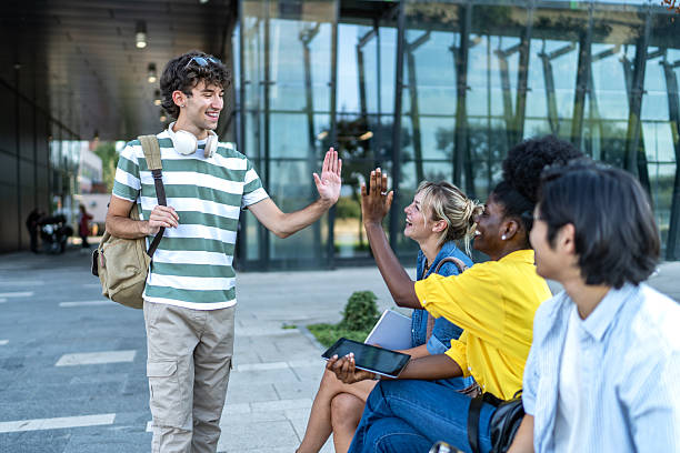 istock Happy students giving high five outdoors after university exam 2234549954