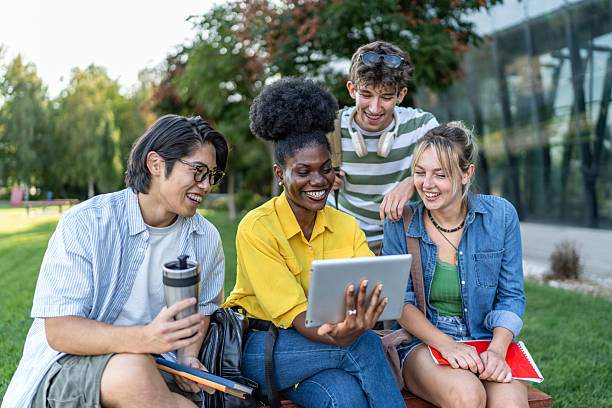 istock University students using digital tablet and smiling together outdoors 2234550092
