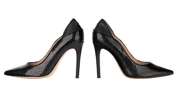 Isolated pair of black stiletto shoes with pointed toes and snake leather texture on white background