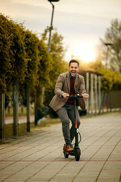 istock Man enjoys riding electric scooter on city path during afternoon with sunset backdrop in spring 2234551829