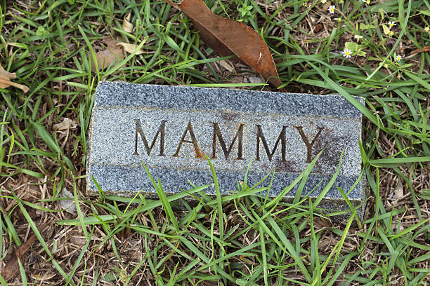 Grave Marker with Flowers and Cross in Cemetery