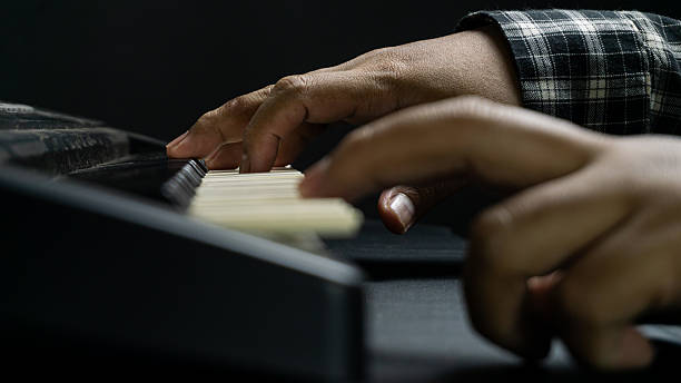istock Close up of piano being played with both hands from direct side view, dark background and instrument tones, concept of classical music, performance, and harmony. 2234553358