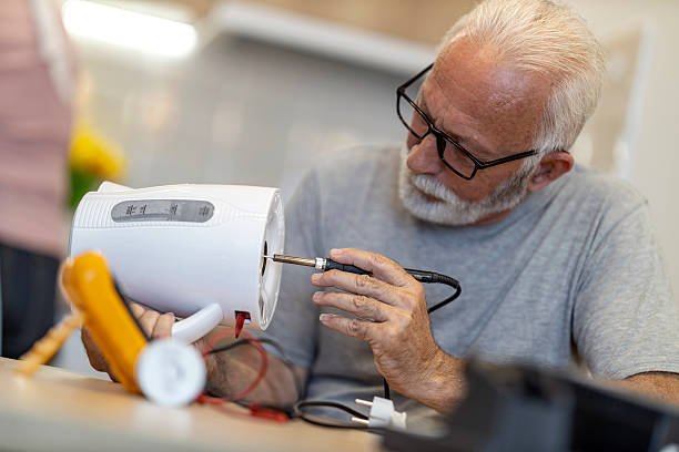 istock Elderly man repairs a broken appliance at home while focused on the task with tools on the table 2234554192