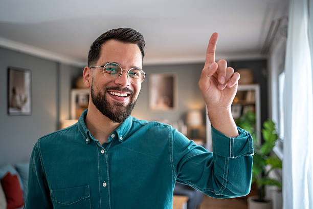 istock Smiling young man pointing up with finger at home 2234556572