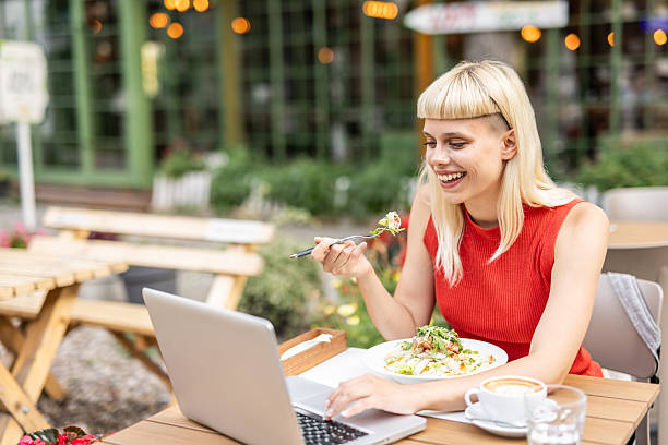 istock Young professional enjoying lunch break, working remotely at outdoor cafe 2234558216