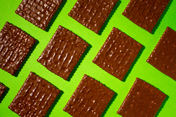 Stock photo of Belgian chocolate cookies and biscuits. A pick and mix selection of indulgent Belgian chocolate cookies / biscuits / Viennese wafer curls directly placed on a red velvet tablecloth. An elegant and decadent arrangement ready for a Christmas party gathering.