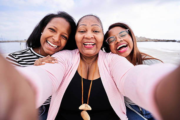 istock Happy mother and daughters taking a selfie at the beach 2234564706