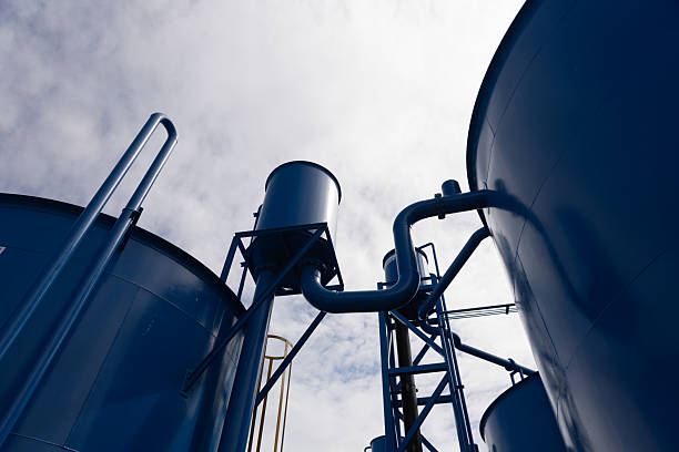 New industrial infrastructure, featuring two large blue steel tanks with a connecting platform and safety railings, Water treatment factory