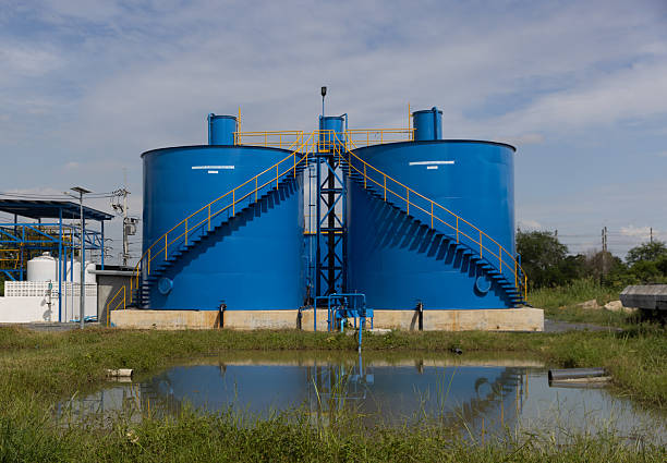New industrial infrastructure, featuring two large blue steel tanks with a connecting platform and safety railings, Water treatment factory