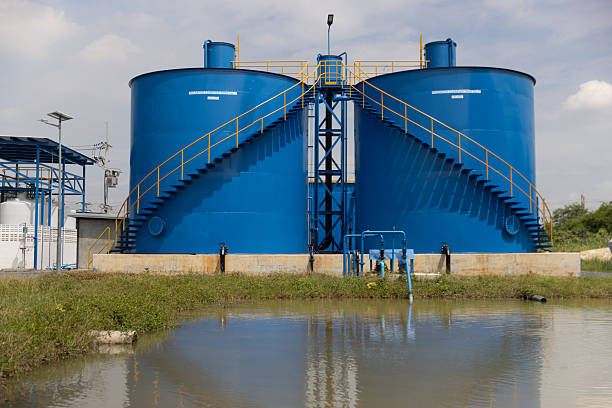 New industrial infrastructure, featuring two large blue steel tanks with a connecting platform and safety railings, Water treatment factory