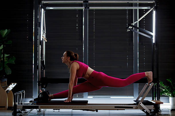 istock Fit woman practicing an advanced stretching exercise on a reformer in a modern studio during daylight hours 2234571466