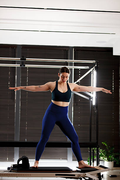 istock Pilates practitioner demonstrates balance and strength on reformer in modern studio during morning session 2234571472