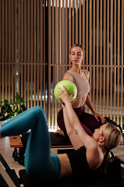 istock Women engaged in a fitness class using a resistance machine in a contemporary studio during afternoon hours 2234572019