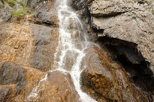 istock A turbulent stream of a cascading waterfall flows down a steep cliff on a cloudy summer day. 2234583893