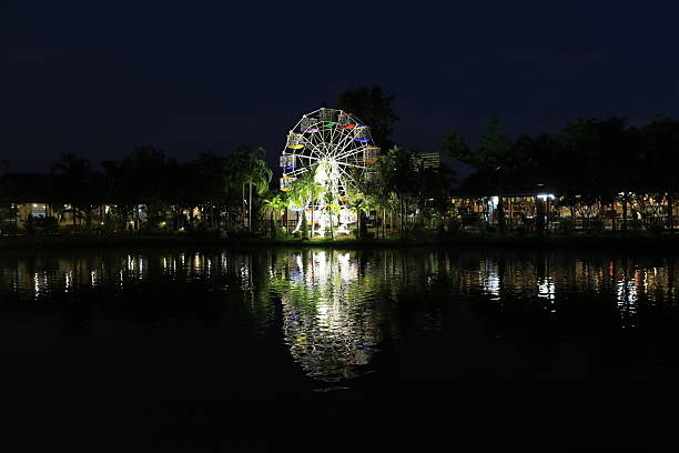 istock The Ferris wheel and its lights at night reflect on the water surface. 2234585700