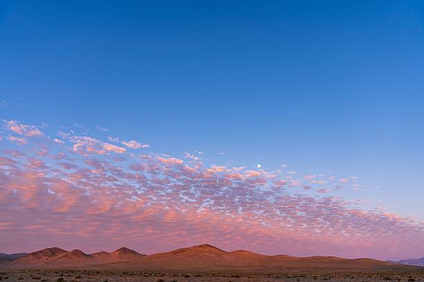 istock A scenic desert landscape with mountains under a vibrant sunset sky and scattered clouds. 2234585740