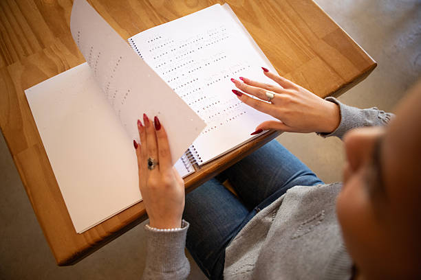 istock Woman's hands reading a cafe menu written in Braille 2234590520