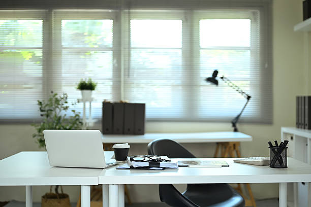 istock Modern office desk with laptop, coffee cup, and documents in bright workspace 2234598459