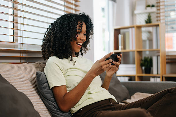 istock frican woman using the smartphone and tablet on the sofa at home 2234599697
