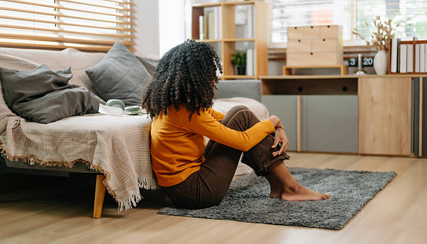 istock woman sit Depression Dark haired  pensive glance Standing by window and anxiety Copy space. 2234599708