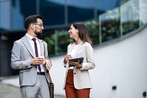 istock Business people talking and smiling outdoors during coffee break 2234606004
