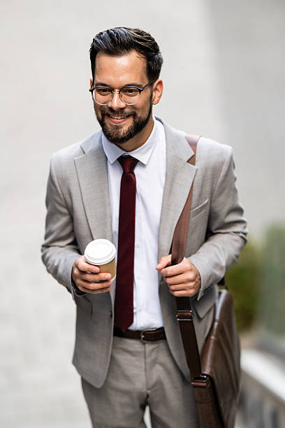 istock Smiling businessman walking with coffee and bag 2234606120