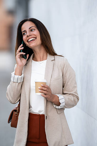 istock Businesswoman walking and talking on phone while drinking coffee 2234606417