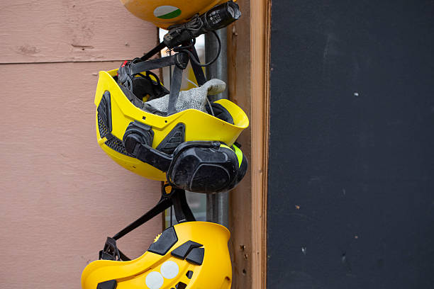 Three hard hats hanging outside a building site