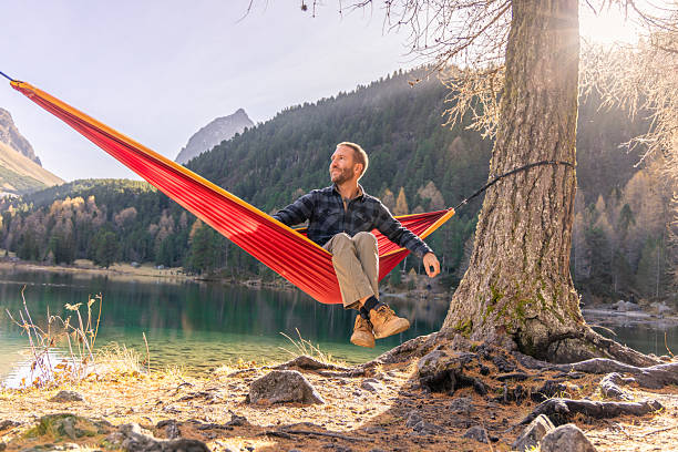 istock Man Relaxing in Hammock by Mountain Lake 2234607669