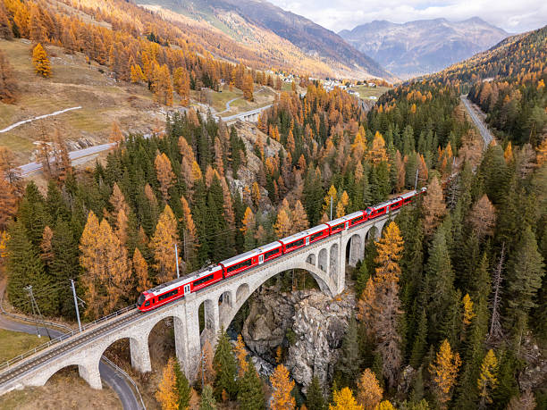 istock Red Train Crossing Stone Bridge in Autumn Forest 2234608534
