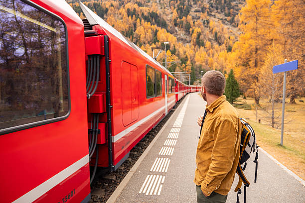 istock Man Waiting for Train at Autumn Mountain Station 2234609770