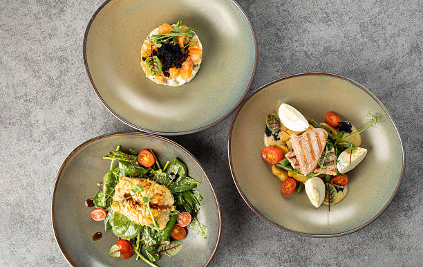 istock Three beautifully plated gourmet dishes featuring fresh ingredients, vibrant colors, and artistic presentation on elegant ceramic plates, showcasing culinary creativity and fine dining experience 2234609900