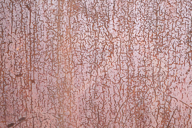 Close-Up View Of Peeling Cracked Paint On Rusted Metal Surface, Showing Alligatoring Pattern, Aged Texture, And Distressed Grunge Background In Pink And Brown Tones. Concept: Decay, Weathering, Industrial Surface, Abstract Texture, Copy Space.