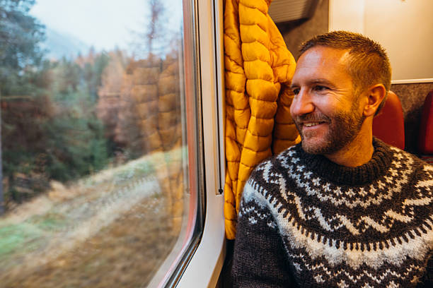 istock Smiling Man Enjoying Scenic Train Ride 2234611729