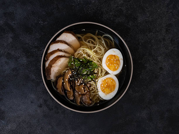 istock A vibrant and inviting ramen bowl featuring succulent chashu pork, perfectly softboiled eggs, and fresh garnishes on black background. 2234612871