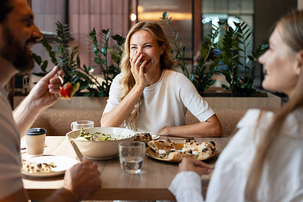 Friends laughing and eating together at a restaurant