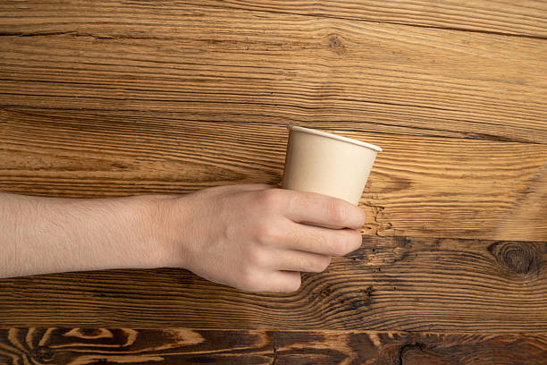 istock Hand Holds Cup, Empty Paper Cup in Hands, Coffee Mug, Teacup, Hot Beverage Mockup, Cup in Arms 2234616161