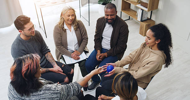 istock Speaker, therapy and ball with people in support group for meeting, healing and community. Counseling session, solidarity and rehabilitation workshop with above of men and women for wellness 2234616467