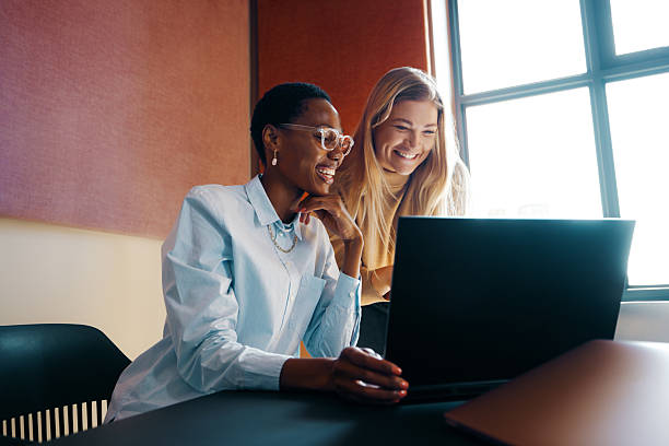 istock Two young women smiling while working together on a laptop 2234617066