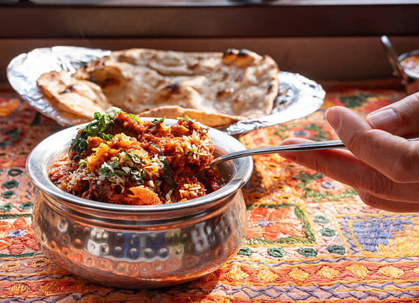 Lamb curry with tomatoes and fiery chili, traditional Indian Laal Maas served in a metal dish