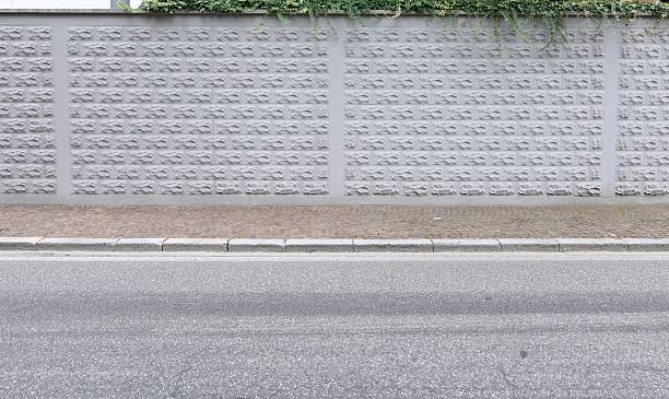 istock Surrounding wall with stone effect concrete tiles, sidewalk and street in front 2234618225