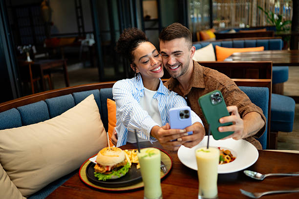 istock Young couple sharing dining experience at tropical restaurant, engaging with their online followers 2234618785