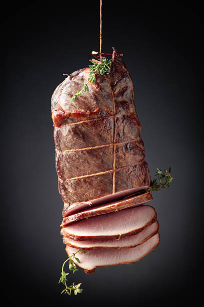 istock Sliced smoked gammon with thyme branches on a black background. 2234620218